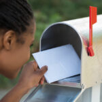 Close-up,Of,Woman,Putting,Letter,In,Mailbox