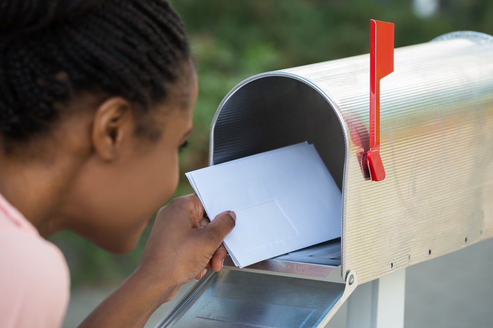 Close-up,Of,Woman,Putting,Letter,In,Mailbox